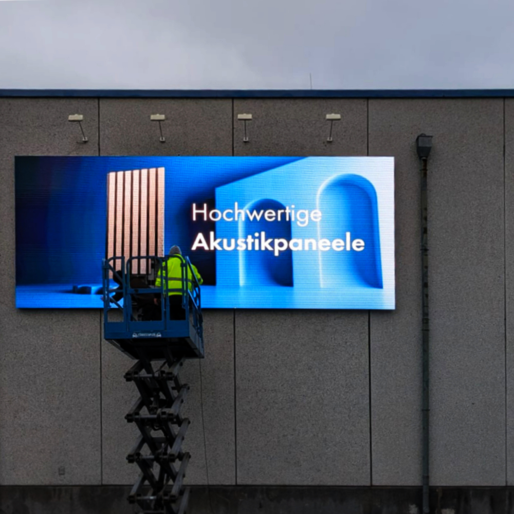 Nahaufnahme der Installation des LED-Displays für Außenwerbung bei Akustikpaneele-Hersteller "By Jacobsen".
